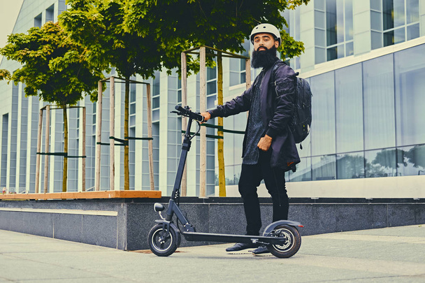Bearded man posing on electric scooter - 写真・画像