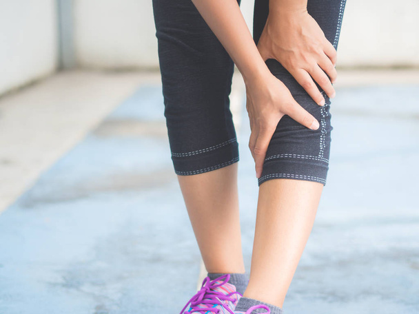Closeup runner sport knee injury. Woman in pain while running. S - Photo, image