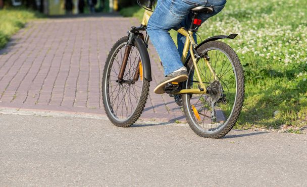 cyclist goes by bicycle down street - Фото, зображення