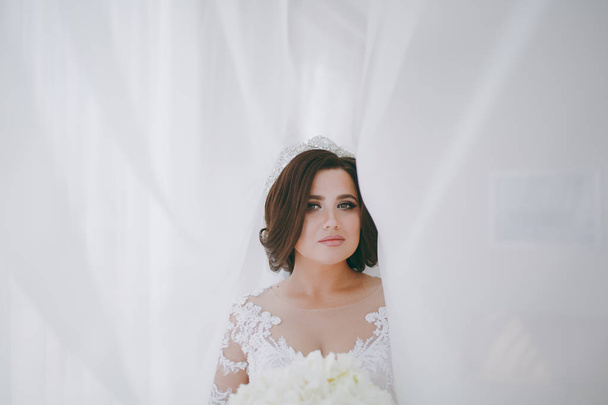 Beautiful bride in wedding dress in apartment - Fotografie, Obrázek