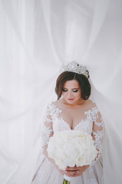Beautiful bride in wedding dress in apartment - Fotografie, Obrázek