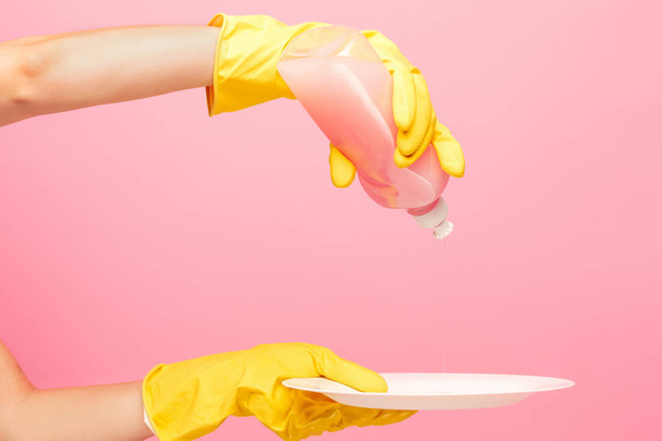 Hands in yellow protective gloves washing a plate - Foto, Bild
