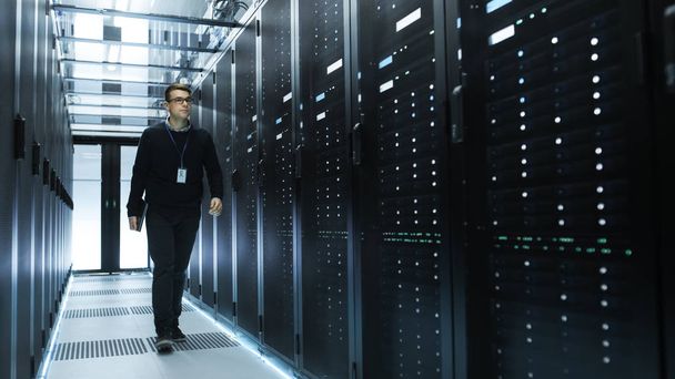 IT Engineer Holding Notebook and Walking Through Data Center Ful - Foto, Imagen