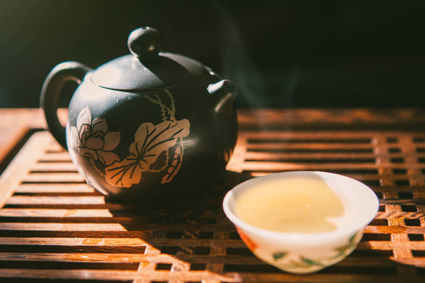 Cerimonia del tè cinese. Teiera e una tazza di tè verde puer su tavola di legno con una piccola quantità di vapore. Cultura tradizionale asiatica
. - Foto, immagini