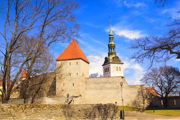 Schöne Aussicht auf den Mädchenturm mit der angrenzenden Festungsmauer und der Kuppel des Turms der olevistischen Kirche in Tallinn, Estland an einem sonnigen Tag - Foto, Bild