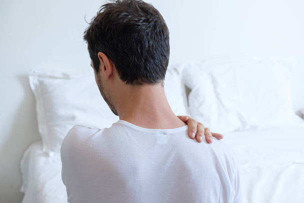 Homem sentindo dor nas costas na cama depois de dormir
 - Foto, Imagem