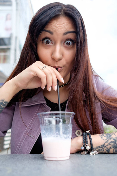 young brunette woman is shocked drinking icy milky cocktail - Foto, Imagem