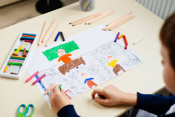 Дитина малює пастельний малюнок свого вчителя в шкільному класі
. - Фото, зображення