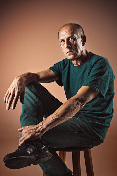 Worried mature man sitting at studio - Valokuva, kuva
