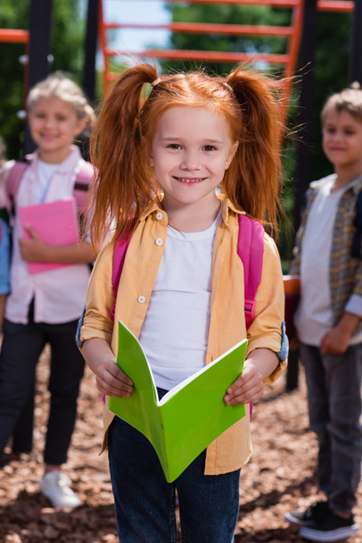 child with book on playground - Zdjęcie, obraz