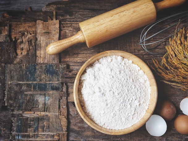 Farine de cuisson avec rouleau à pâtisserie et fouetter les œufs sur fond en bois
 - Photo, image