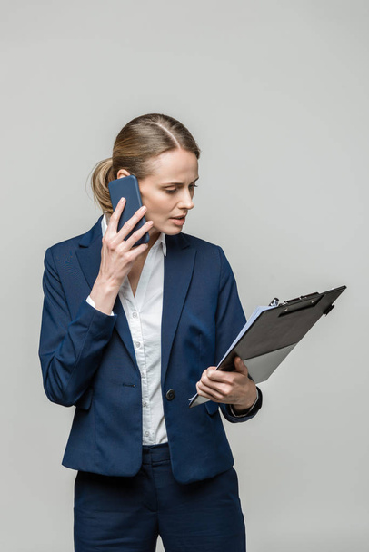 mujer de negocios con papeleo y teléfono inteligente
 - Foto, imagen