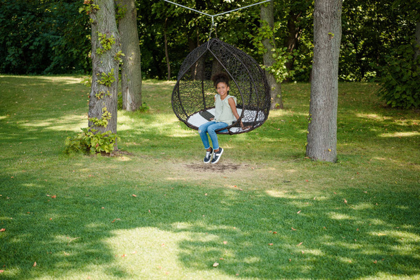 Kid swingen op schommel in park - Foto, afbeelding
