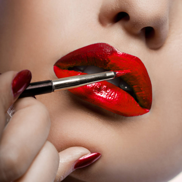 Girl paints her lips with lipstick - Foto, Imagen
