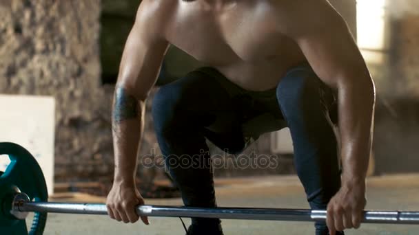Close-up of a Muscular Shirtless Man Lifting Heavy Barbell and Doing Deadlift Bodybuilding Exercise in the Industrial Gym Building. - Záběry, video