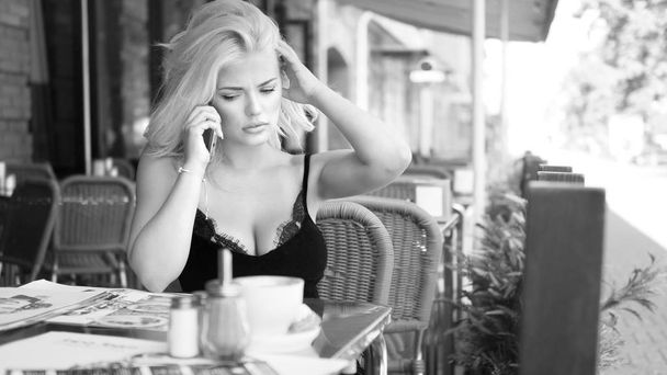 Young cheerful female tourist enjoying the local sweet desserts while sitting modern coffee shop after a long walk in the surrounding city area, talks sell phone. Retro style. - Φωτογραφία, εικόνα