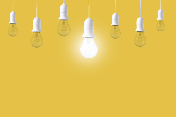 黄色の背景違い電球。新しいアイデアの概念 - 写真・画像
