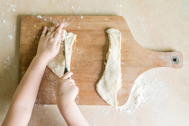 childrens hands cutting raw dough - Photo, Image