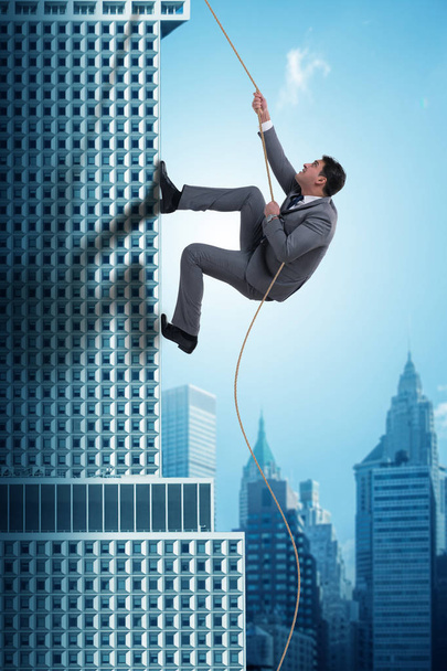 Geschäftsmann klettert in Challenge-Konzept auf Wolkenkratzer - Foto, Bild
