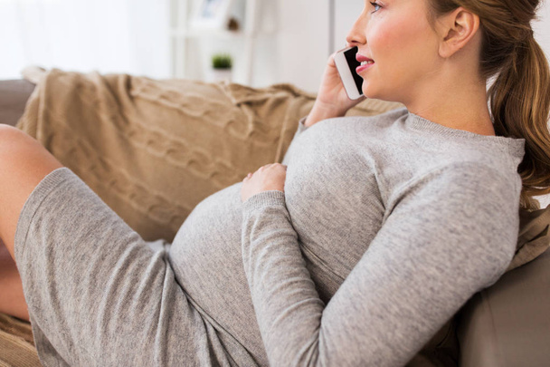 happy pregnant woman calling on smartphone at home - Foto, Imagen