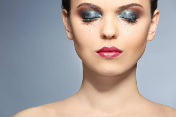 Beautiful young woman with creative makeup on color background, closeup - Zdjęcie, obraz