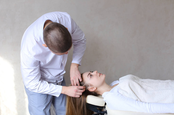Komea kaveri hieronta terapeutti tekee pään hieronta tyttö clien
 - Valokuva, kuva