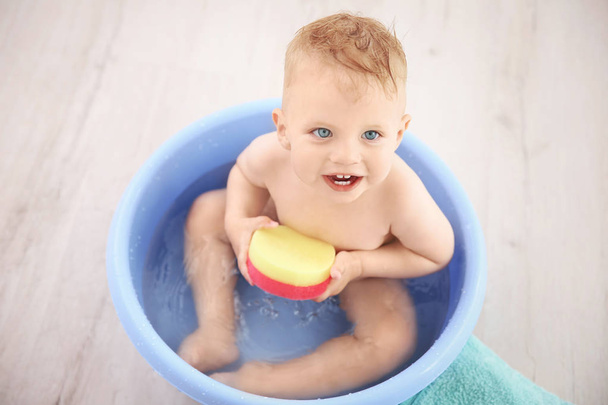 Little baby boy washing in bath basin at home - Zdjęcie, obraz