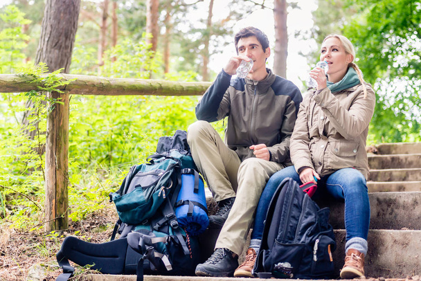 Backpackers taking rest and having mineral water - Photo, Image