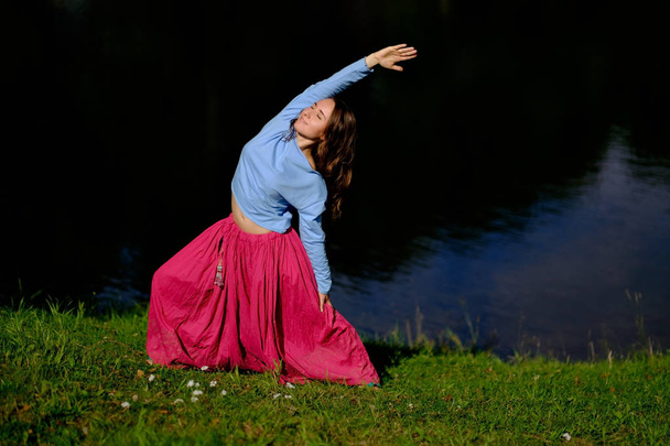 Sporty fit caucasian woman doing asana Virabhadrasana 2 Warrior pose posture in nature. - Photo, Image