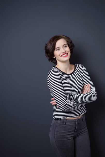 Young cheerful woman against dark blue background - Foto, afbeelding
