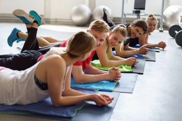 Fünf glückliche Freunde im Gespräch während eines Yoga-Kurses in der Gruppe - Foto, Bild