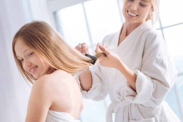 woman combing long hair of daughter - 写真・画像