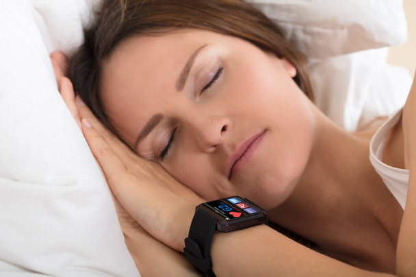 Woman Sleeping With Smart Watch Showing Heartbeat Rate - Foto, imagen