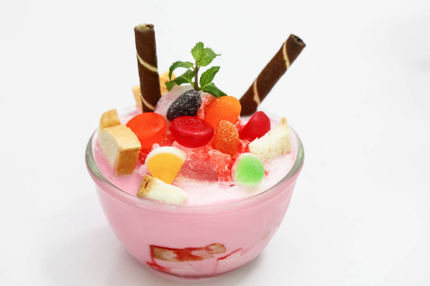 Pink milk smoothie in cup have topping is jelly bread and biscuit - Фото, зображення