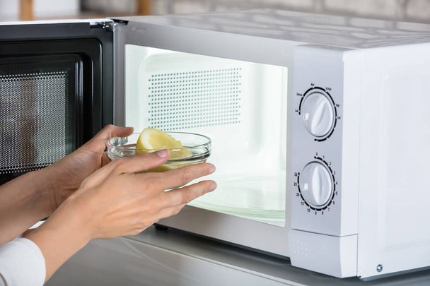 Woman Putting Lemon In Oven - Photo, Image