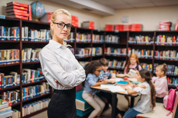 teacher with kids in library - Photo, Image