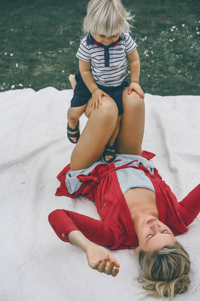 Mother having fun with her son on blanket - 写真・画像