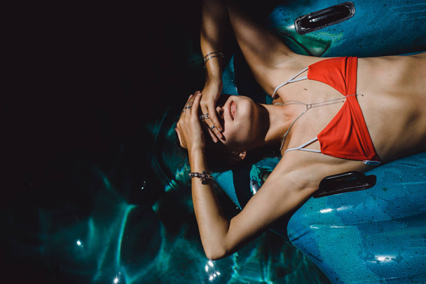 Woman in red bikini lying on inflatable circle - Fotografie, Obrázek