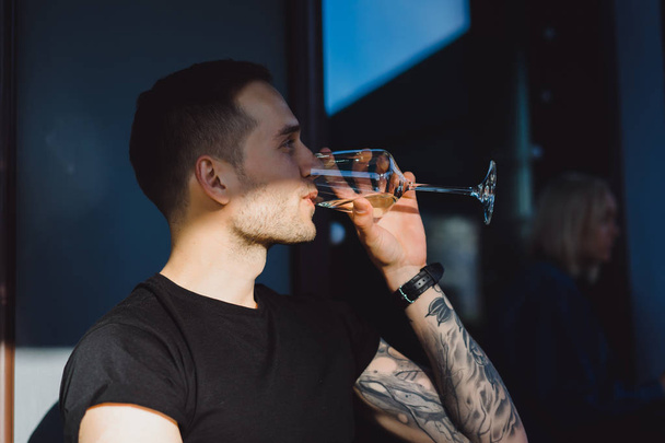 tattooed man drinking wine - Foto, imagen