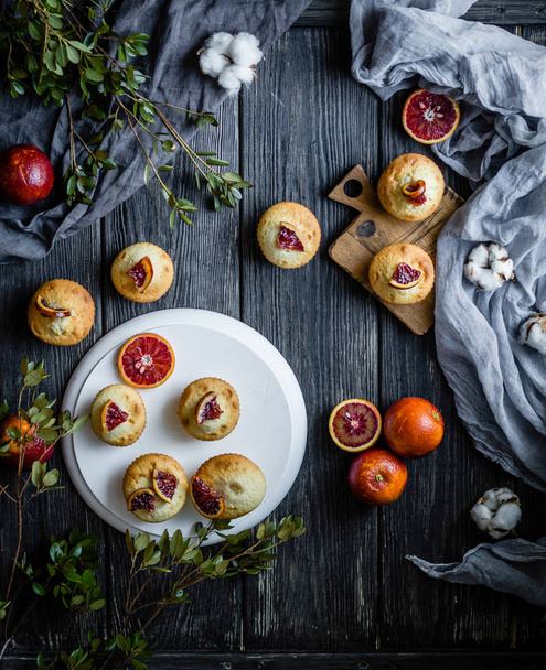 Muffins with blood oranges on black wooden table - Foto, imagen