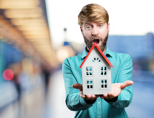 young blonde man with a house - Foto, afbeelding