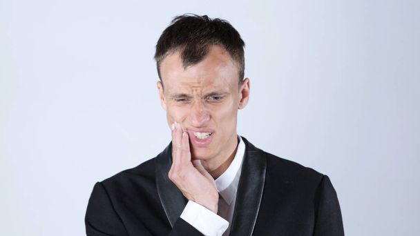 Zahnschmerzen. frustrierter junger Mann berührt seine Wange, weißer Hintergrund - Foto, Bild