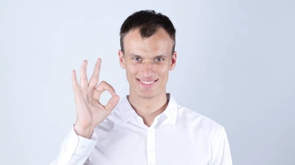 Portrait of a good looking young man with ok hand sign - Photo, Image