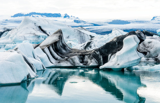 Floating icebergs in the glacial lake Jokulsarlon in Iceland - Фото, изображение