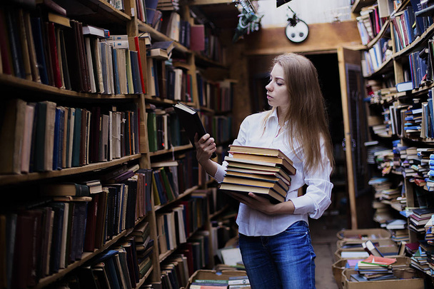 Lifestyle portrait of a lovely student girl in vintage library or bookstore - Fotografie, Obrázek