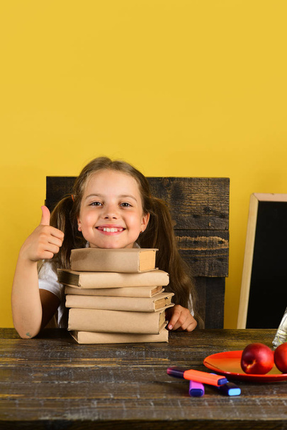 Kid and school supplies on yellow wall background - Foto, afbeelding