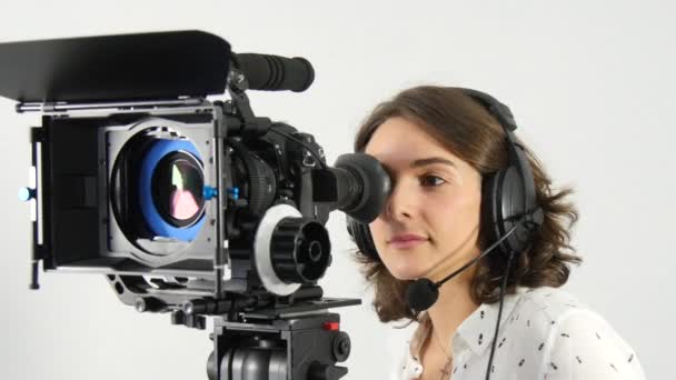 hermosa mujer joven con cámara de vídeo DSLR y auriculares
 - Metraje, vídeo
