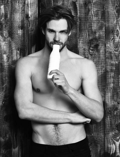Caucasian bearded sexy macho man holding kefir or yogurt - Фото, изображение