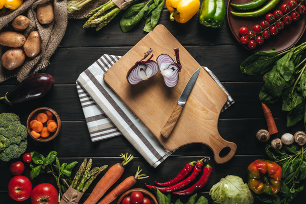 cutting board with onion and knife  - Фото, зображення