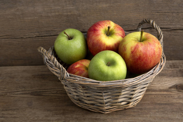 Korf van verse appelen op houten achtergrond - Foto, afbeelding